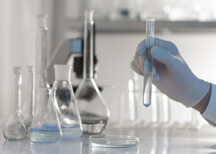 close-up-hand-holding-tube-with-solution